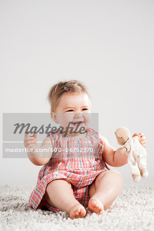 Portrait of Baby Girl Laughing and holding Teddy Bear, Studio Shot