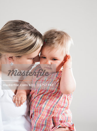 Portrait of Mother holding Crying Baby Girl, Studio Shot