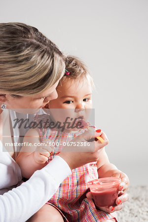 Portrait of Mother Feeding Daughter, Studio Shot