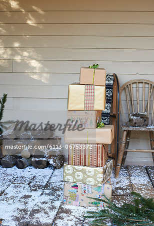 Stack of Christmas gifts on snowy patio