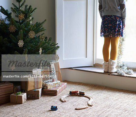 Girl with Christmas tree and gifts