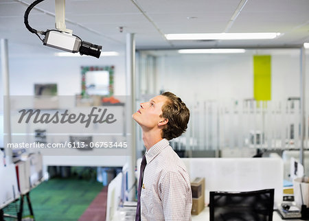 Businessman examining security camera in office