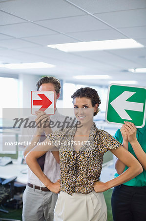 Business people holding arrows in office