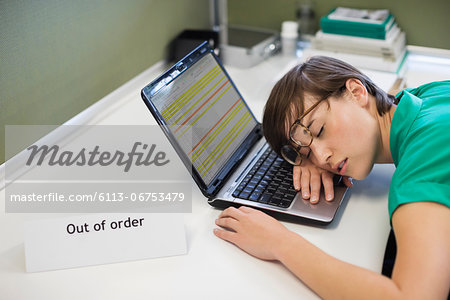 Businesswoman sleeping on 'out of order' laptop