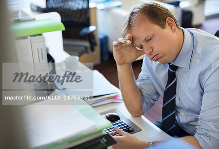 Businessman sighing at desk