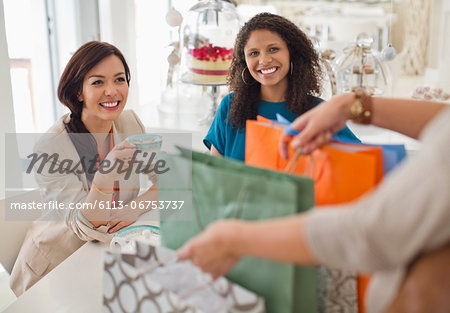 Woman showing friends shopping bags