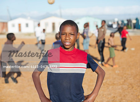 Boy standing in dirt field