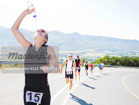 Runner spraying water on rural road