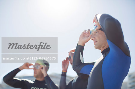 Triathletes adjusting goggles outdoors