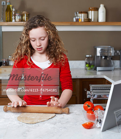 Girl rolling dough in kitchen