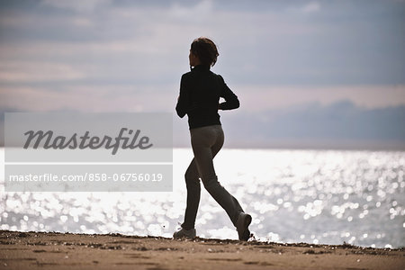 Young Woman Running On The Beach