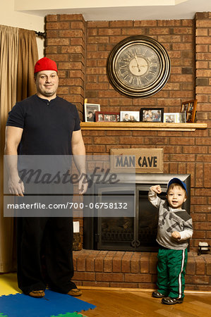 Father and Son Standing by Fireplace in Man Cave