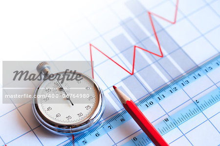 Business concept. Closeup of stopwatch and red pencil on paper background with business chart