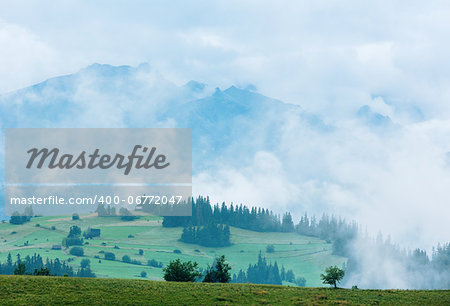 Summer misty mountain village outskirts with Tatra range  (Gliczarow Gorny, Poland)