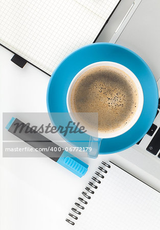 Blue coffee cup and office supplies. View from above. On white background