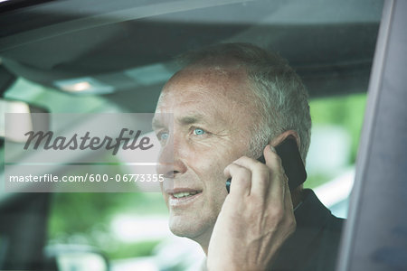 Businessman Talking on Cell Phone in Car, Mannheim, Baden-Wurttemberg, Germany