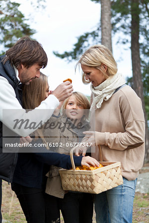 Family with two kids picking mushrooms