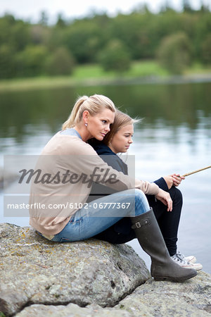 Daughter and mother fishing at lake