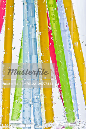 Colorful drinking straws in glass of water
