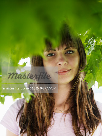 Portrait of young woman under tree