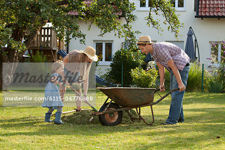 Family with one child working together in garden, Munich, Bavaria, Germany