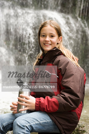 Girl With Thermos Bottle In Front Of A Waterfall, Bavaria, Germany, Europe
