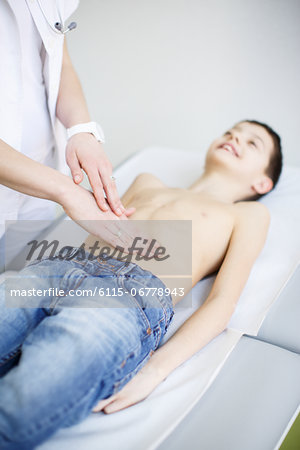Female doctor examining abdomen of boy, Osijek, Croatia