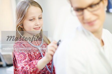 Girl is using playfully a stethoscope on female doctor, Osijek, Croatia