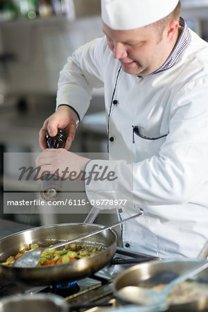 Chef Seasoning Food In Pan