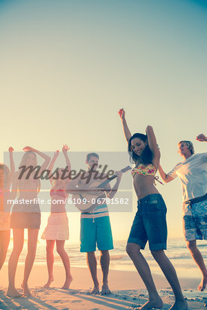 Friends dancing and having fun on the beach