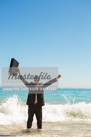 Businessman in the sea raising his arms