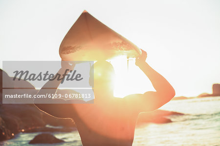 Surfer holding his surfboard and looking at the sea