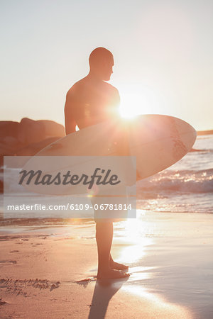 Attractive man holding his surfboard