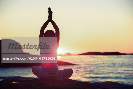 Woman doing yoga on a beach