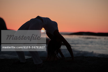 Silhouette of a woman doing crab yoga pose