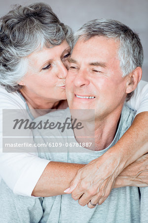 Cheerful mature woman kissing her husband