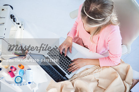 Blonde fashion designer working on her laptop