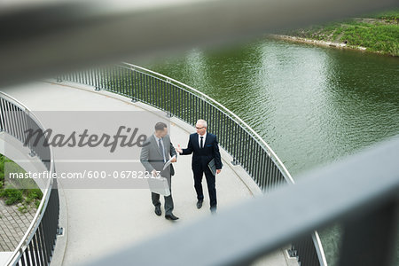 Mature businessmen on walkway talking, Mannheim, Germany