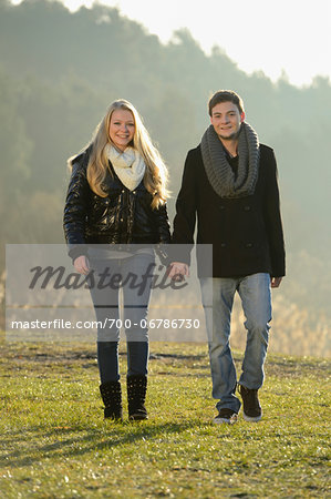 Young couple walking and holding hands in an autumn landscape, Bavaria, Germany