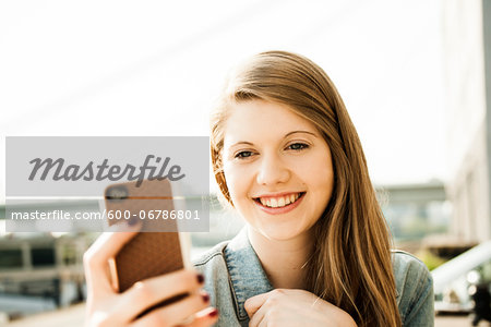 Young woman outdoors looking at smartphone