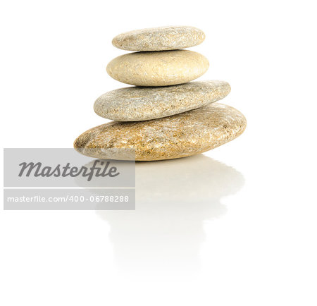 Pile of four pebble stones stacked in a pyramid isolated on a white reflective surface