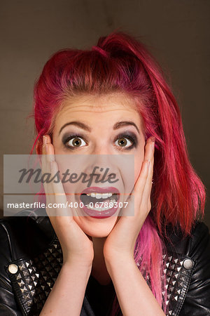 Young punk rocker female with hands on face