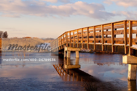 wooden bridge over river during sunrise