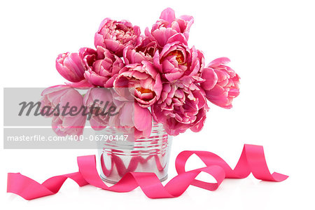 Pink tulip flower arrangement in a metal vase with ribbon over white background.