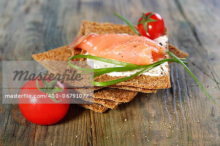 Toast the bread from grain and salmon on a wooden table.