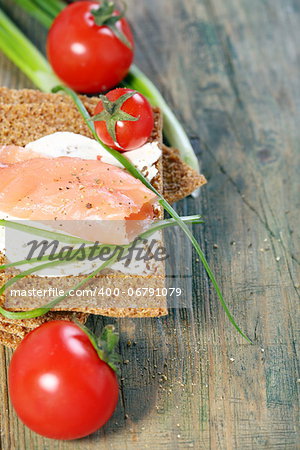 Toast the bread from grain and salmon on a wooden table.