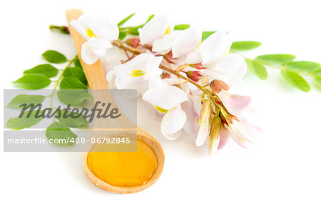 Honey in spoon with acacia flower on white background