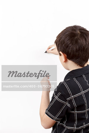 young boy student in a classroom writing on a empty whiteboard