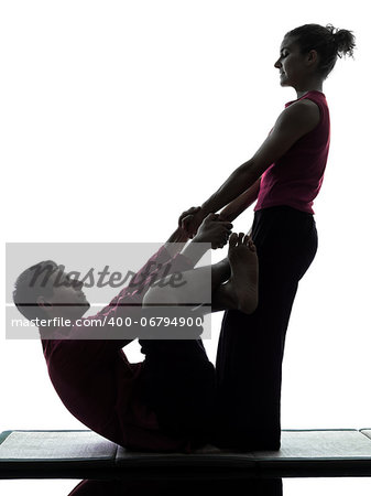 one man and woman performing thai massage in silhouette studio on white background