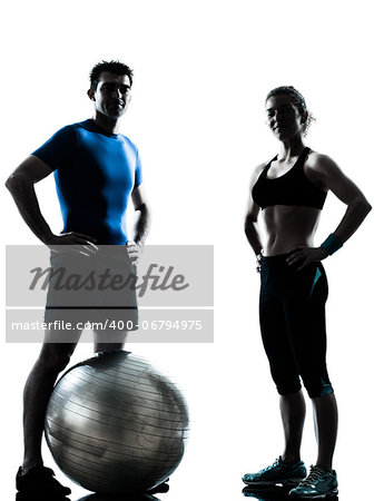 one caucasian couple man woman personal trainer coach exercising fitness ball silhouette studio isolated on white background
